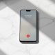 A Google Pixel 10 smartphone resting face-up on a smooth light grey marble surface, incoming phone call screen visible with a bank name displayed and a verified checkmark indicator, 45-degree angle, 50mm lens, shallow depth of field, soft natural window light from the left, long diffused shadows across the marble surface, realistic screen reflections, no hands, no people, no overlaid icons or text, no watermark, sharp focus, photorealistic, 16:9