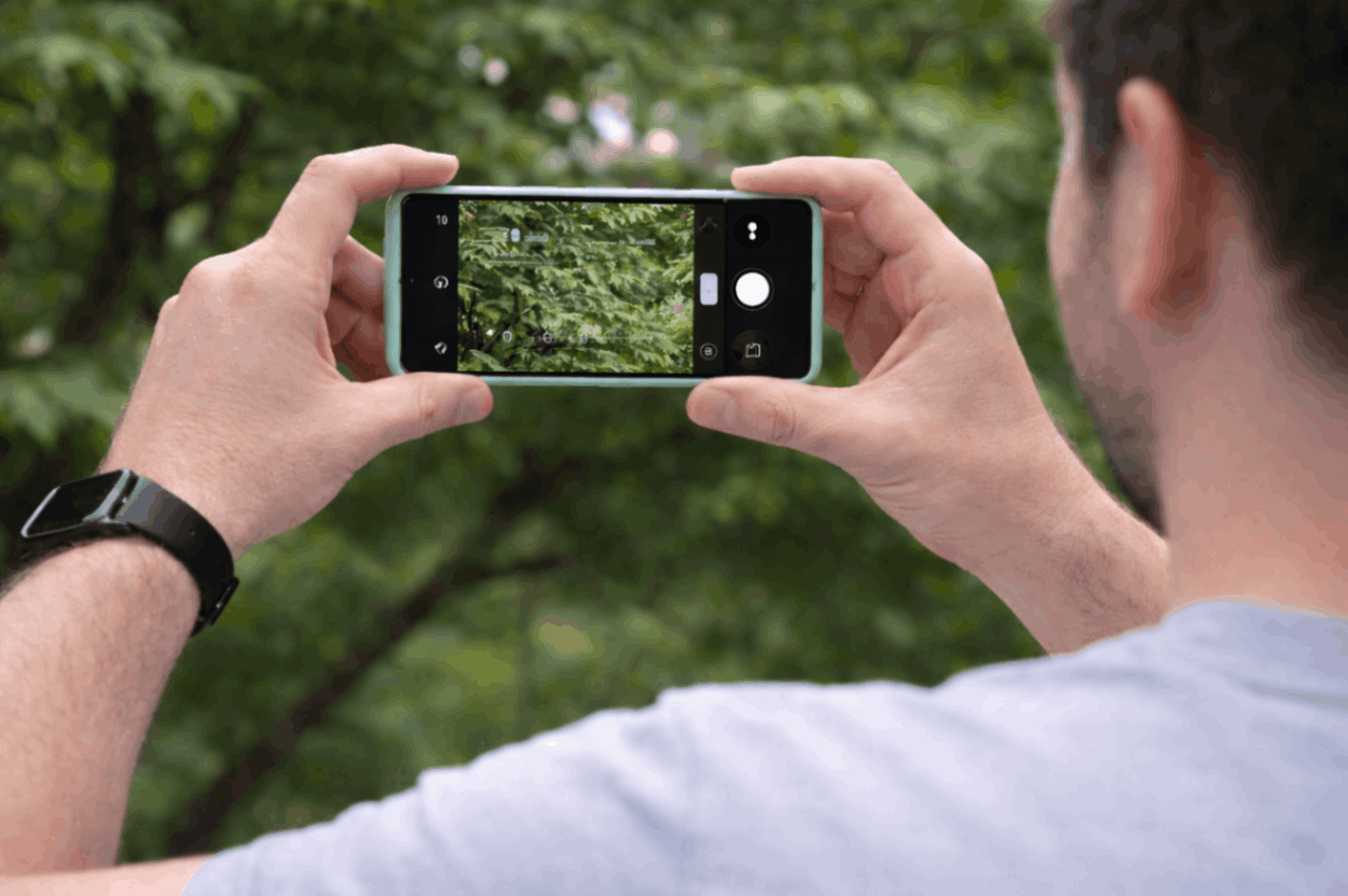 Why I Don't Buy Flagship Android Phones Anymore 2 Man photographing lush greenery with smartphone